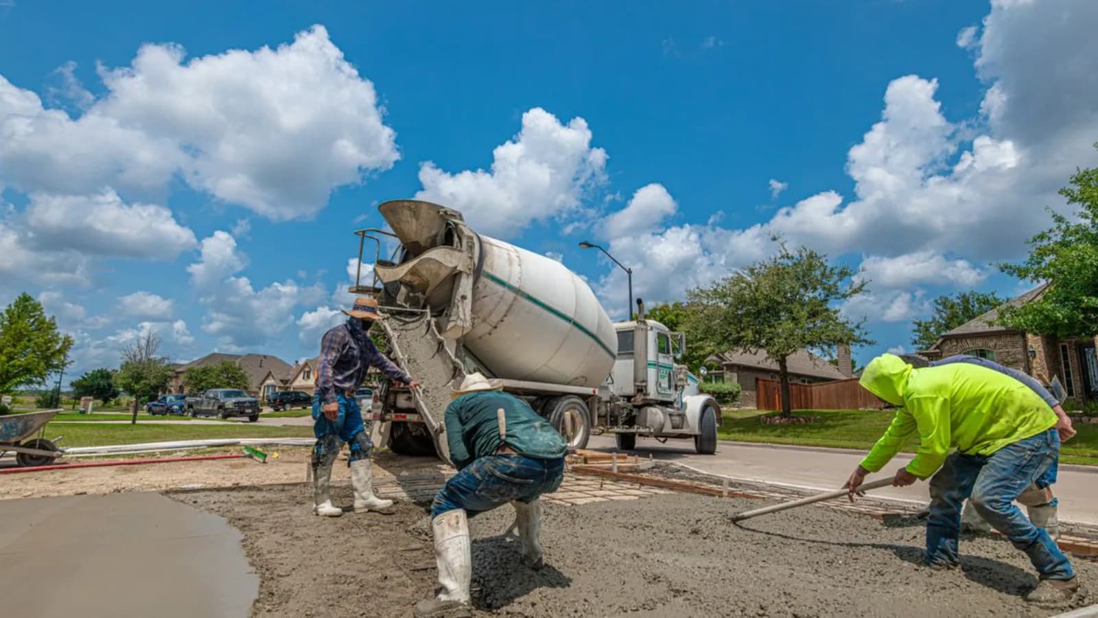 Concreters screeding a freshly poured driveway